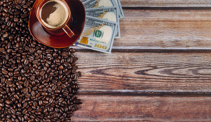 American dollars and coffee beans and coffee cup on wooden table background.