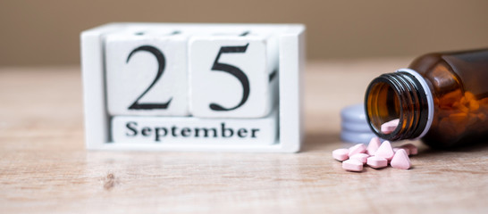25 September of calendar wooden and drug on table, World pharmacist day concept