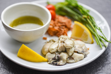 Fresh oysters served on plate - Oyster Salad with vegetable tomato lemon and herb  seafood sauce in the restaurant