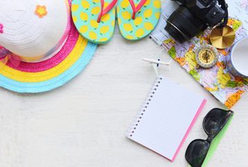 Travel background concept - Planning Essential vacation trip items summer travel accessories with camera sunglasses hat flip flops compass map notebook and plane for Traveler's , top view