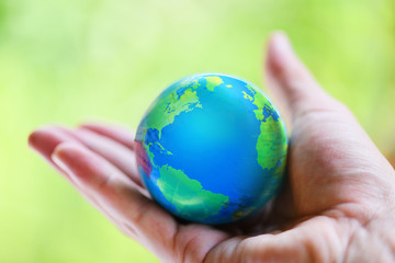 The world in the hand with nature background / hand holding globe with map and environment green planet save the earth