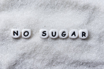 no sugar text blocks with white sugar with ant on wooden background / suggesting dieting and eat less sugar for health concept