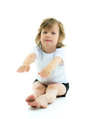Charming little girl doing gymnastic exercises in the studio on