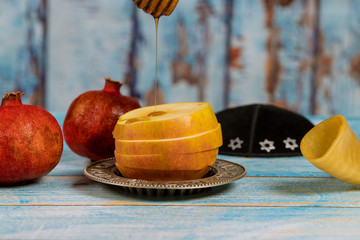 Apple and honey, traditional food of jewish New Year Rosh Hashana torah book, kippah yamolka talit