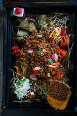 vertical view closeup restaurant dish of crumbled bark bread and sliced radish