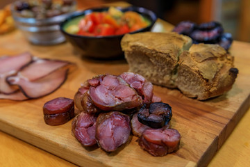 Board of traditional Portuguese food with blood and pork sausage, ham, bread, olives at a restaurant in Porto, Portugual