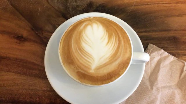 A cup of mocha coffee in ceramic cup on a wooden background, push in