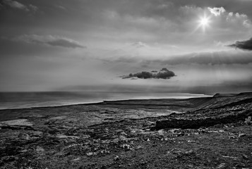 Black and white of lava rock and dark clouds