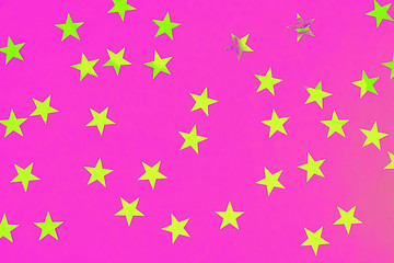 Star shaped confetti on a pink background. Festive background. Holiday concept. Top view, flat lay