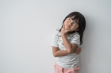 dreamy asian little girl looking up in white background