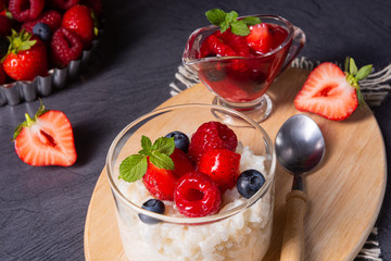 delicious milk rice with different berries and red fruit jelly