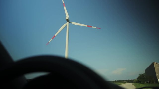 Looking Out Of A Car At A Spinning Windmill On A Sunny Afternoon.