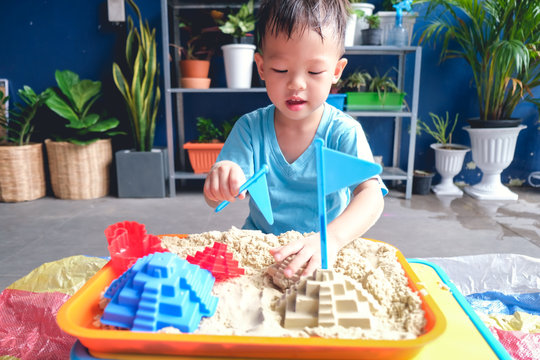 Cute Smiling Asian 3 - 4 Years Old Toddler Boy Playing With Kinetic Sand In Sandbox At Home / Nursery / Day Care, Fine Motor Skills Development, Montessori Education, Creative Play For Kids Concept