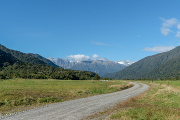 GRavel dirt road winding its way into the southern alps in the west coast of New Zealand