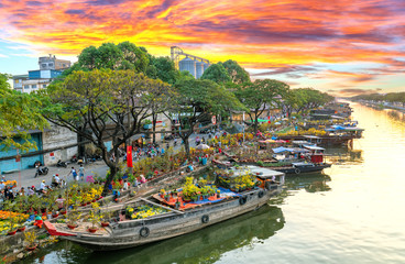 Ho Chi Minh City, Vietnam - February 3rd, 2019: Sunset boat dock flower market along canal wharf. This is place farmers sell apricot and other flowers on Lunar New Year in Ho Chi Minh city, Vietnam