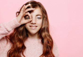 Beautiful little fashion model girl on pink background.