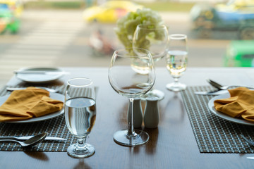 Fresh romantic breakfast table next to morning briliant light window with glasses prepare for the meal