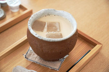 陶器のカップで飲むアイスカフェラテ