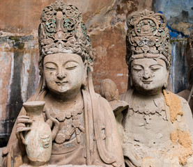 Statues of disciples or followers in front of giant Buddha with one  at Dazu Rock Carvings at Mount Baoding or Baodingshan in Dazu, Chongqing, China. UNESCO World Heritage Site. 