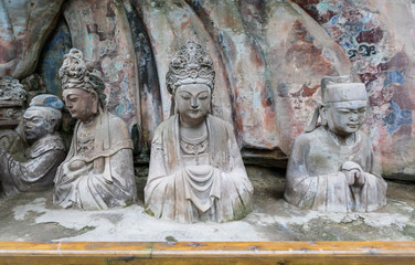 Statues of disciples or followers in front of giant Buddhan at Dazu Rock Carvings at Mount Baoding or Baodingshan in Dazu, Chongqing, China. UNESCO World Heritage Site. 