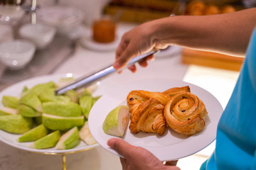 Woman hand taking food in buffet