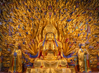 Golden sculpture of Avalokiteshvara Buddha or Guanyin with thousand hands at Dazu Rock Carvings at...