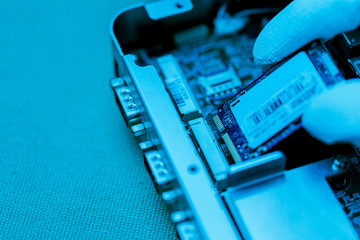 Hand holding tiny electronic circuit board inserting to the socket, abstract technology background,...