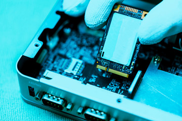 Hand holding tiny electronic circuit board inserting to the socket, abstract technology background,...