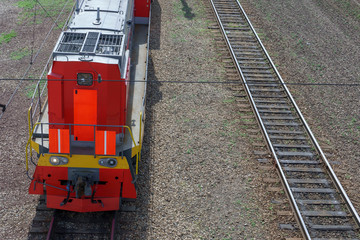 Railway locomotive on rails. Red bright color. View from above.