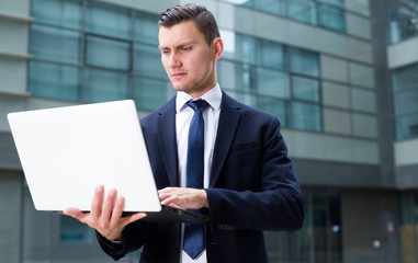 Man 30-33 years old is examining project on a laptop