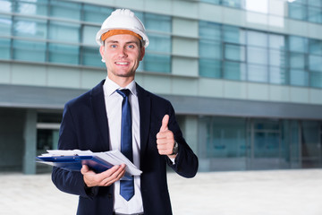 Smiling architector in suit and hat is pleased with realisation his project