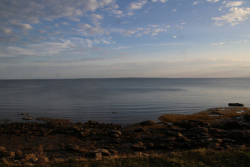A view of the horizon with a rocky beach in the foreground