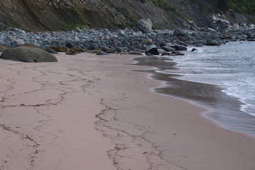Fototapeta premium A sandy beach leading to a rocky beach