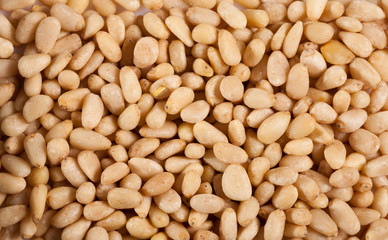 Fototapeta premium Heap pine nuts on wooden board
