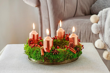 Advent wreath made of moss, cinnamon sticks and rosa canina twigs.