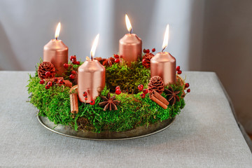 Advent wreath made of moss, cinnamon sticks and rosa canina twigs.