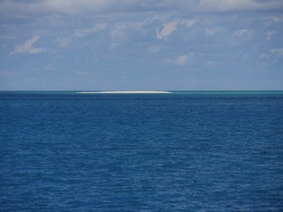 Obraz premium White stretch of sandbar in the middle of the ocean in the distance