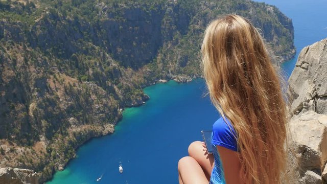 Woman traveller enjoying beautiful view of The Butterfly Valley from the top of the mountain