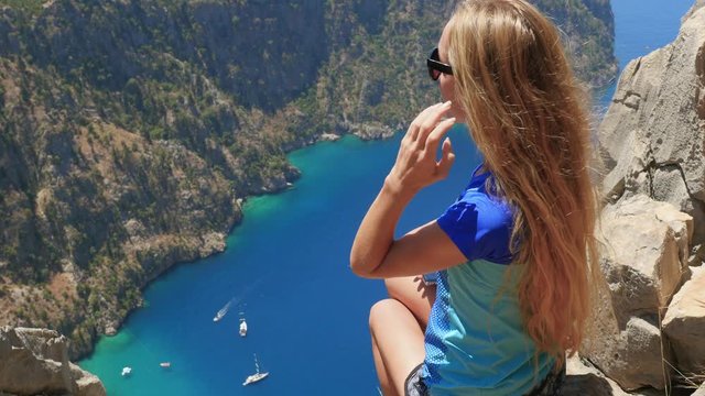 Woman traveller enjoying beautiful view of The Butterfly Valley from the top of the mountain