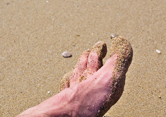 Foot close up with sand on  beach.