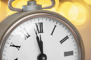 Close up of retro alarm clock on blurred Christmas background with bokeh