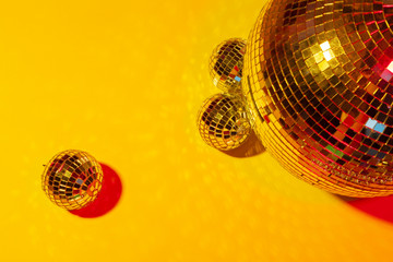 Shiny party disco balls shining in a day light over color background