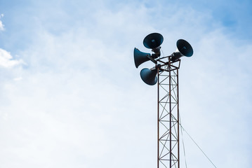 Loudspeakers on the pole against sky.