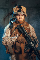 Special forces United States soldier or private military contractor holding rifle. Image on a dark background