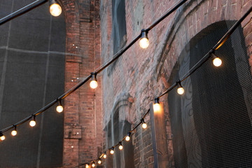 An old patio illuminated by garlands of warm light bulbs