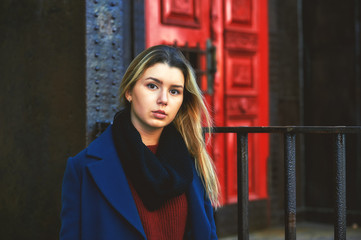 Beautiful young girl in coat and sweater in town
