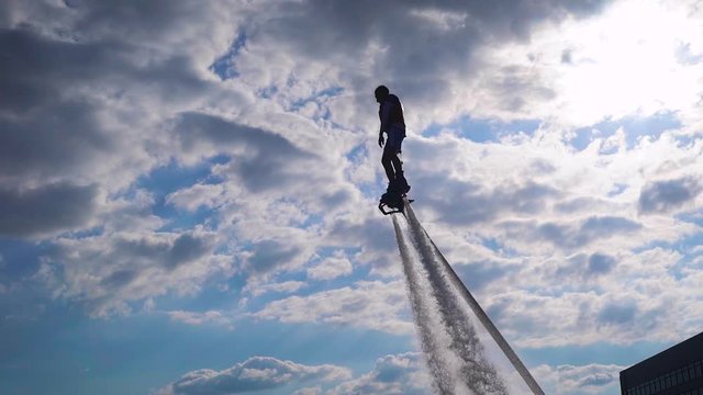 Courageous person doing tricks with jet pack against sky