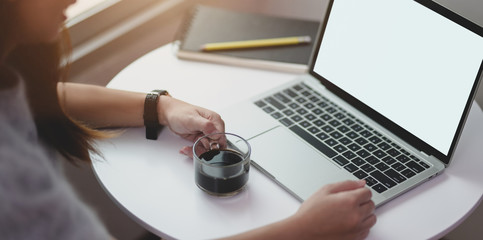 Young female working on her project while drinking a cup of coffee