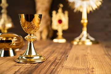 Catholic concept background. The Cross, monstrance, Jesus figure, Holy Bible and golden chalice on...