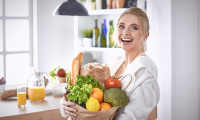Young woman holding grocery shopping bag with vegetables Standi